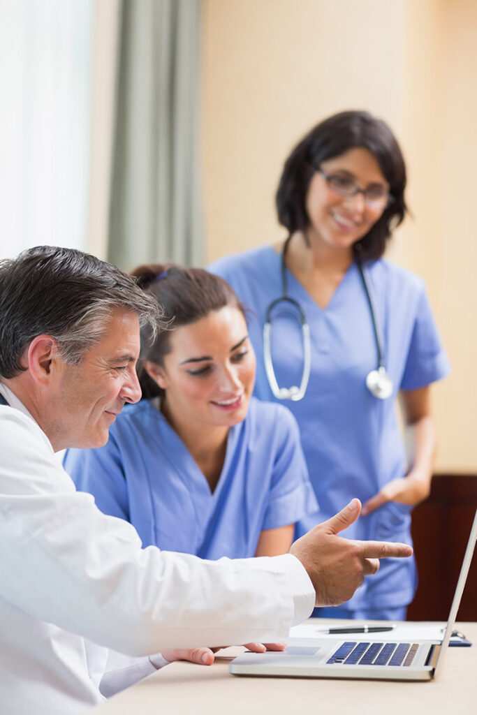 Nurses looking at a laptop and having a discussion