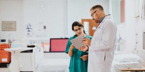 A doctor and nurse communicating a patience chart